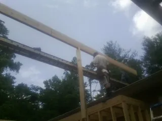 Carpenter setting a ridge beam over a new addition frame — Ice Dam Removal by Roofing Brothers in Southwick