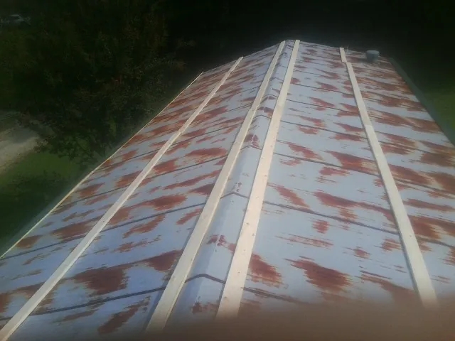 Rusted metal roof panels with new wood purlins before replacement — Storm Damage Roof Repair in Southwick by Roofing Brothers
