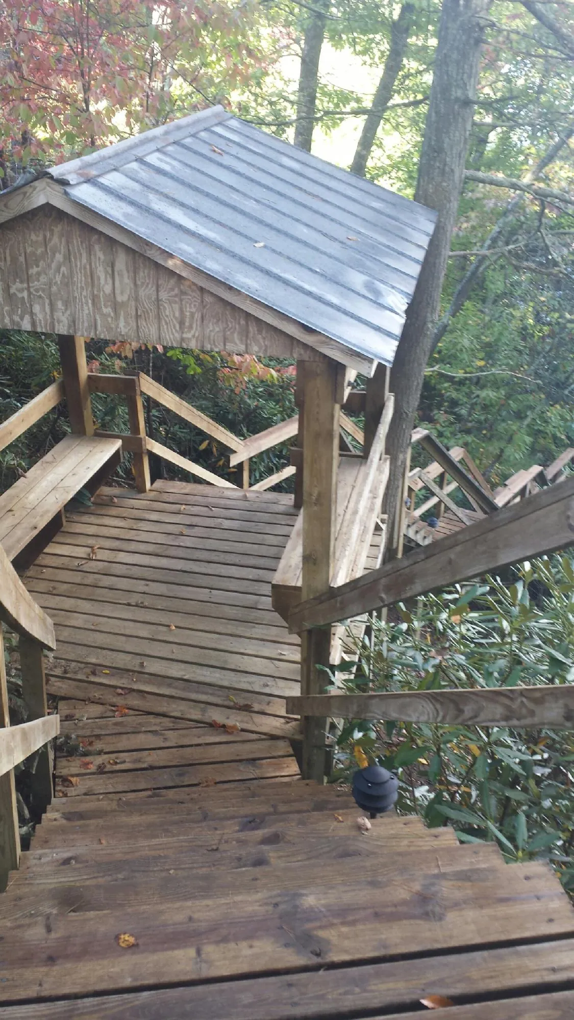 Metal roofed shelter over wooden steps on a wooded walkway — Skylight Repair & Installation work by our crew in Southwick