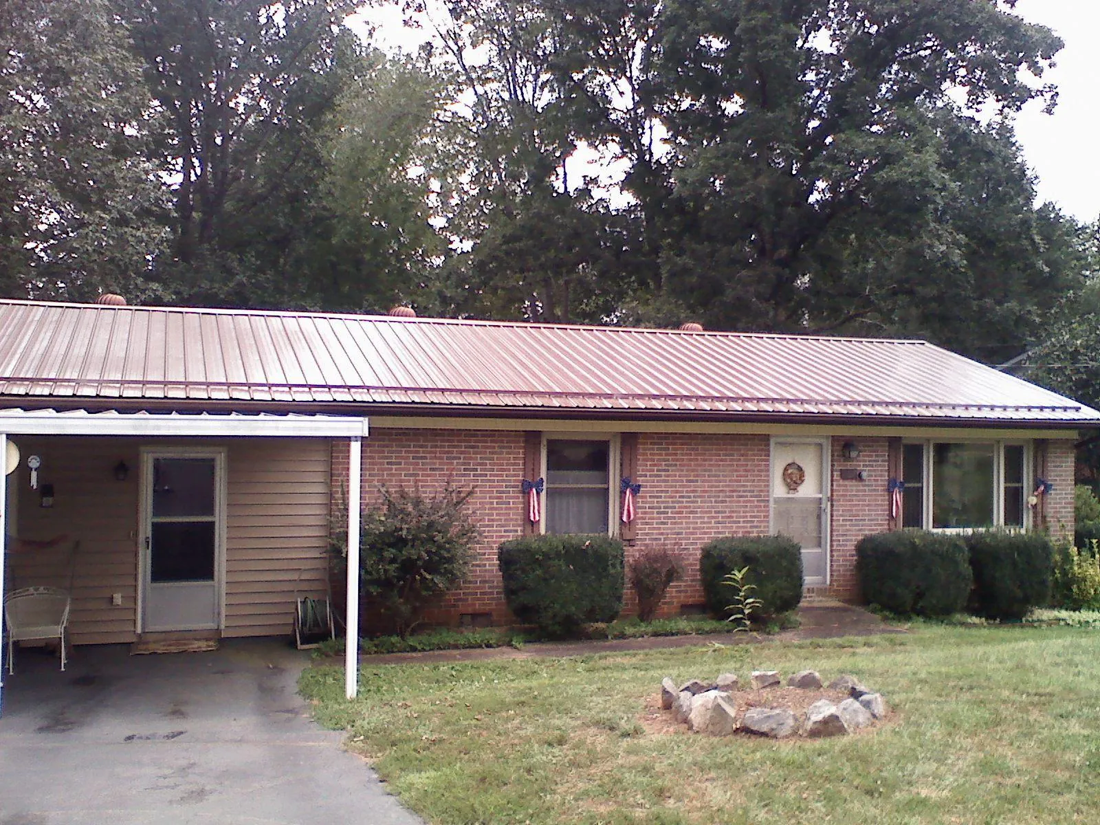 Bronze metal roof and carport on a brick ranch home — Roof Repair work by our crew in Southwick